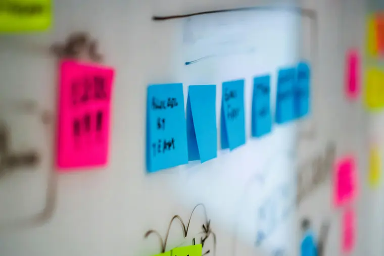 Post it colorati su una lavagna bianca, nel corso di una value stream mapping | Menti Pratiche